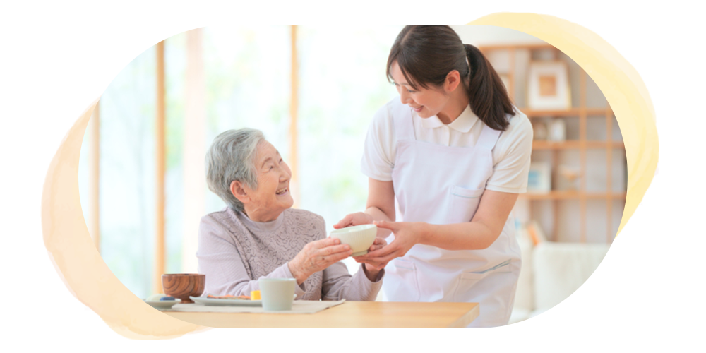 食事を受け取る高齢女性と介護士